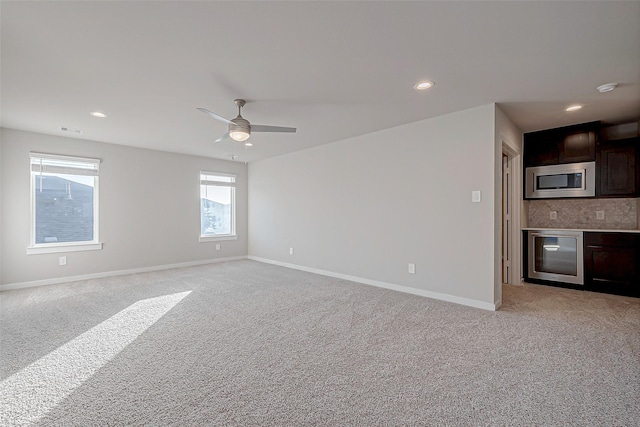 carpeted spare room featuring wine cooler and ceiling fan