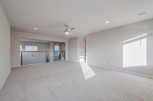 carpeted spare room with ceiling fan