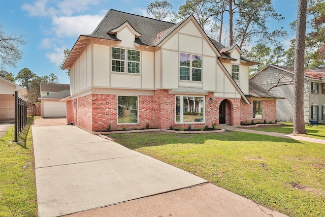 tudor house featuring an outbuilding, a garage, and a front lawn