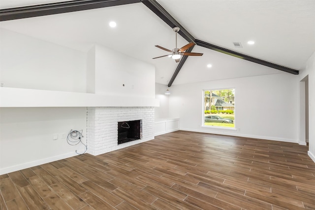 unfurnished living room with vaulted ceiling with beams, a fireplace, dark hardwood / wood-style floors, and ceiling fan