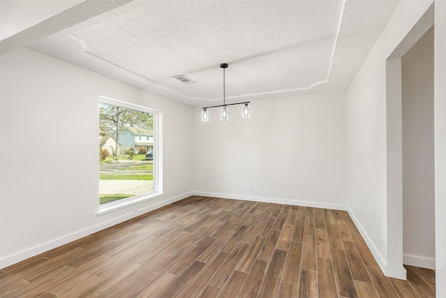 unfurnished dining area featuring hardwood / wood-style flooring and a textured ceiling