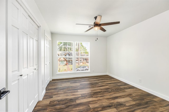 empty room featuring dark wood-type flooring and ceiling fan