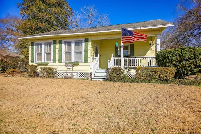 view of front of house with covered porch and a front lawn