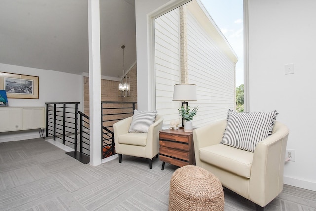 living area with an inviting chandelier and carpet flooring