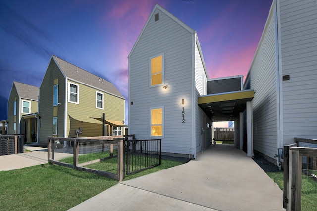 view of front of home with a carport and a lawn