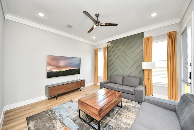 living room featuring hardwood / wood-style floors, ornamental molding, and ceiling fan