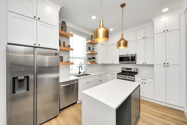 kitchen with white cabinetry, sink, decorative light fixtures, and stainless steel appliances