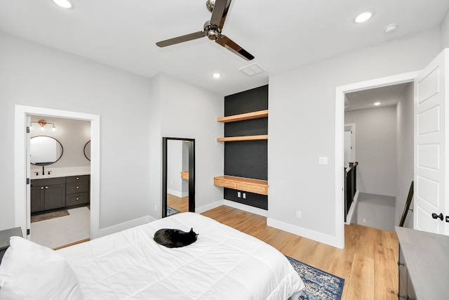 bedroom featuring ceiling fan, ensuite bathroom, and light wood-type flooring