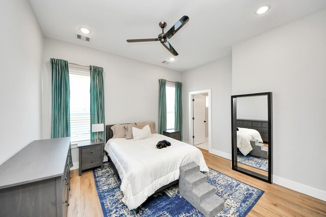 bedroom with multiple windows, light hardwood / wood-style flooring, and ceiling fan