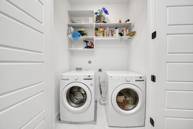 laundry area featuring washing machine and clothes dryer and light tile patterned floors