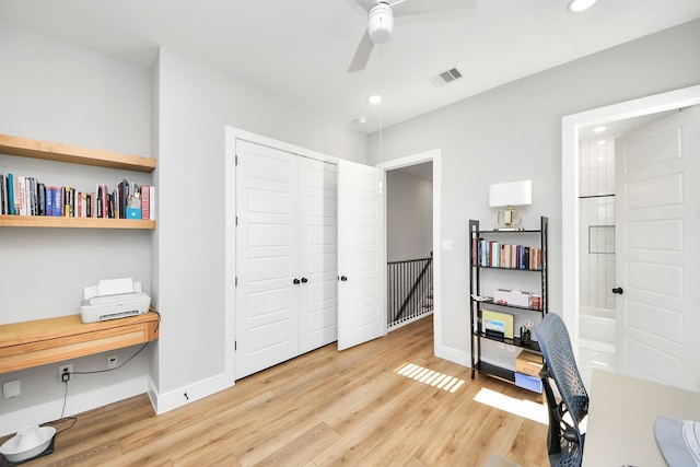 home office featuring hardwood / wood-style flooring, built in desk, and ceiling fan