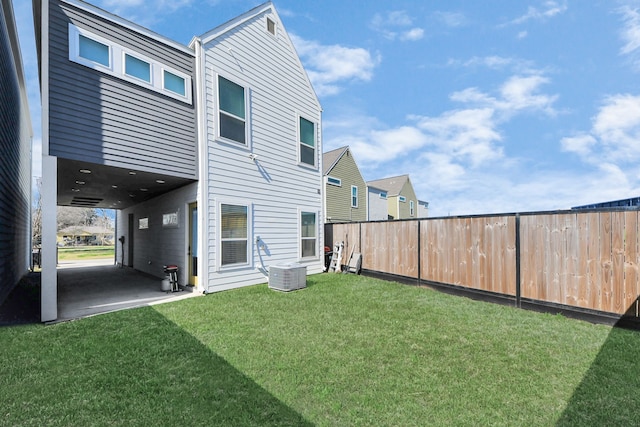 back of house featuring a yard, central AC unit, and a patio