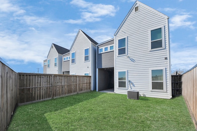 back of property with central AC unit and a lawn