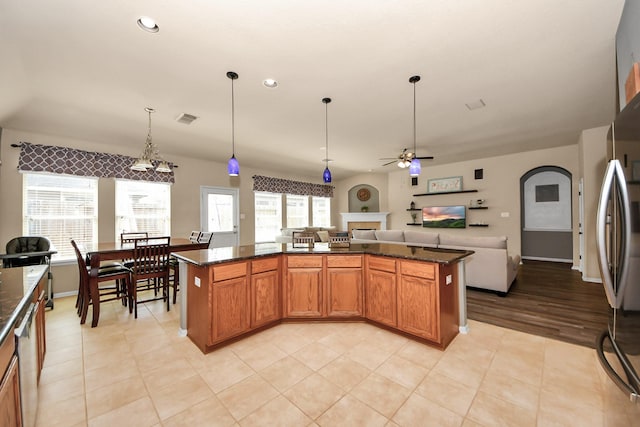 kitchen with a kitchen island, dark stone countertops, and decorative light fixtures