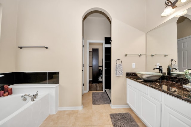 bathroom featuring tile patterned floors, vanity, and a washtub