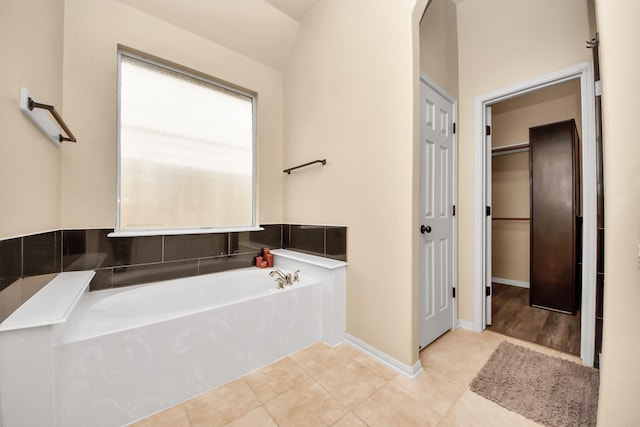 bathroom with a bath and tile patterned floors