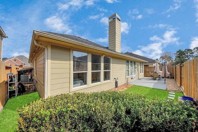 rear view of house featuring a patio area and a lawn