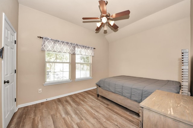 bedroom featuring hardwood / wood-style flooring, vaulted ceiling, and ceiling fan