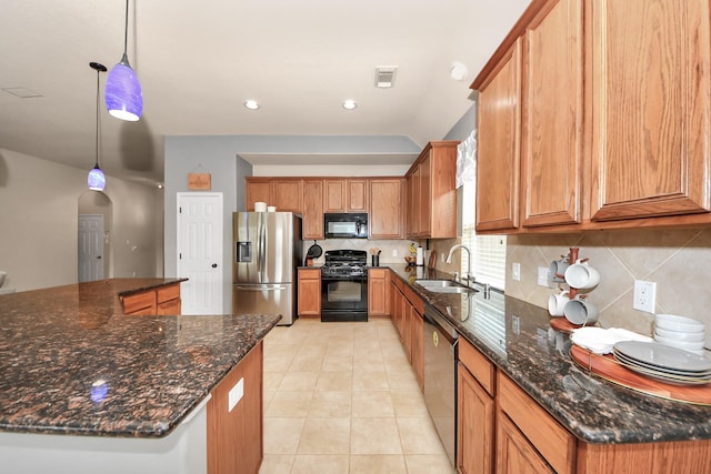 kitchen featuring pendant lighting, sink, appliances with stainless steel finishes, decorative backsplash, and dark stone counters