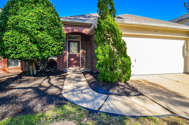 view of front of house featuring concrete driveway, brick siding, and a shingled roof