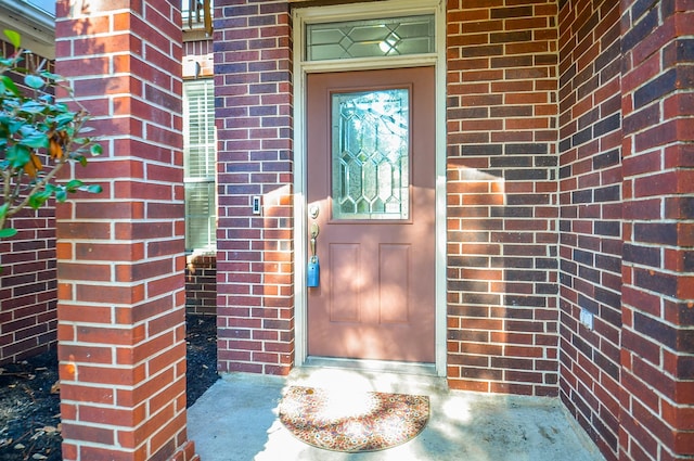 view of exterior entry with brick siding