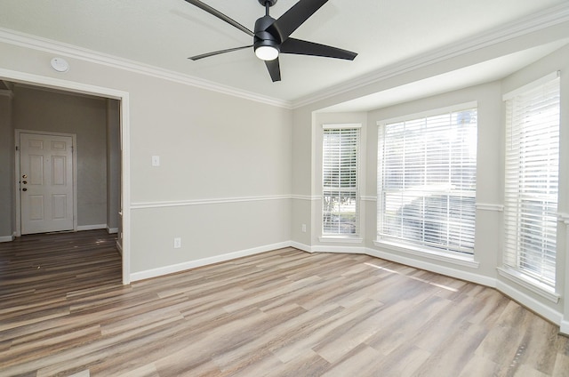 spare room featuring ornamental molding, a ceiling fan, baseboards, and wood finished floors