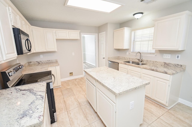 kitchen featuring light stone counters, stainless steel appliances, a sink, baseboards, and a center island