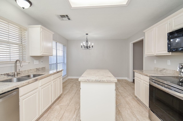 kitchen with visible vents, white cabinets, appliances with stainless steel finishes, a center island, and a sink