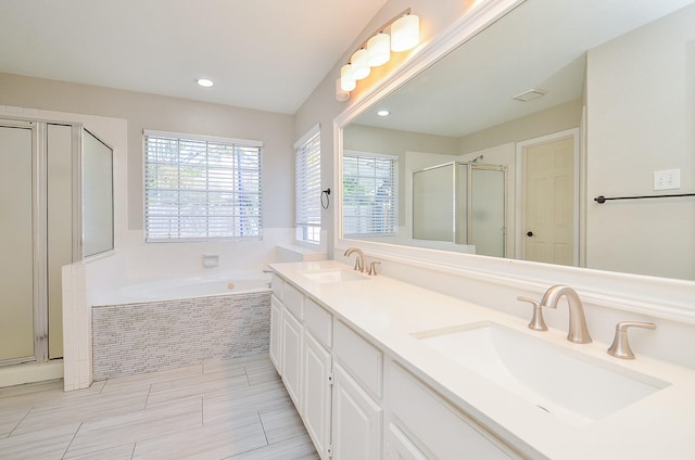 full bath with double vanity, a garden tub, a sink, and a stall shower