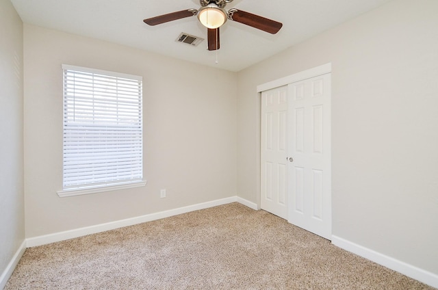 unfurnished bedroom featuring baseboards, carpet, visible vents, and a closet