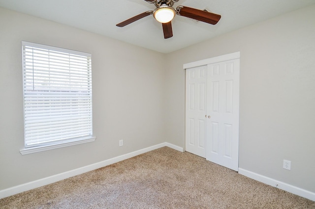 unfurnished bedroom with carpet, multiple windows, baseboards, and a closet