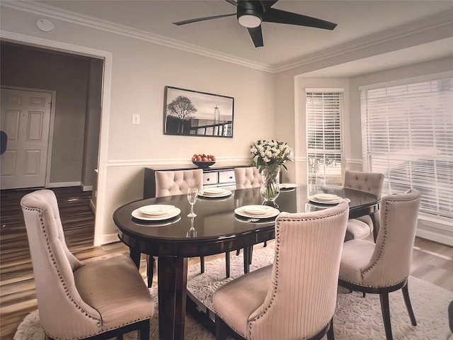 dining area with baseboards, ornamental molding, ceiling fan, and wood finished floors