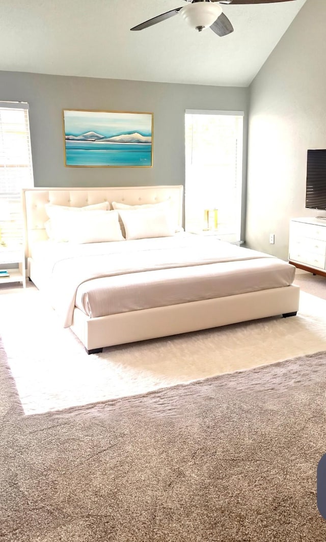 unfurnished bedroom featuring ceiling fan, vaulted ceiling, and carpet flooring