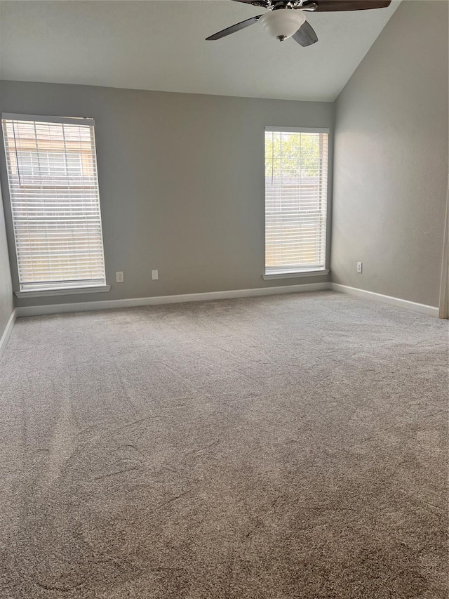 spare room featuring lofted ceiling, carpet floors, a ceiling fan, and baseboards