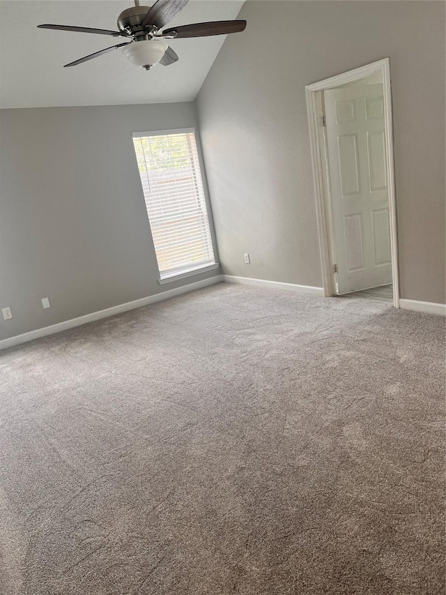 unfurnished room with lofted ceiling, carpet floors, a ceiling fan, and baseboards