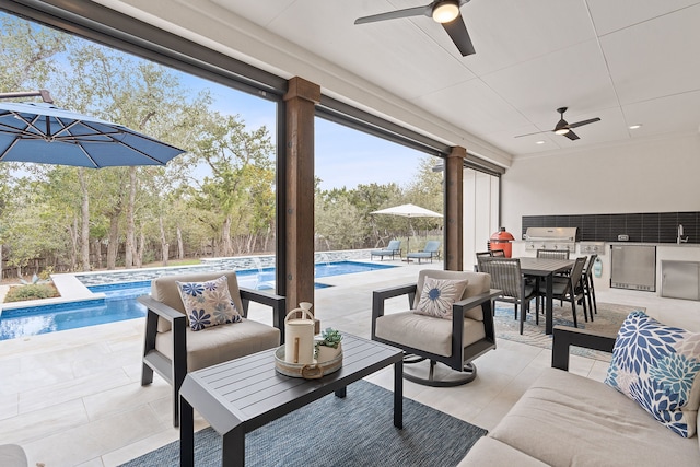 view of patio / terrace with ceiling fan, area for grilling, a grill, and a pool with hot tub