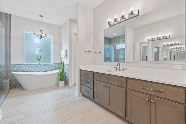 bathroom featuring vanity, hardwood / wood-style flooring, shower with separate bathtub, and a chandelier