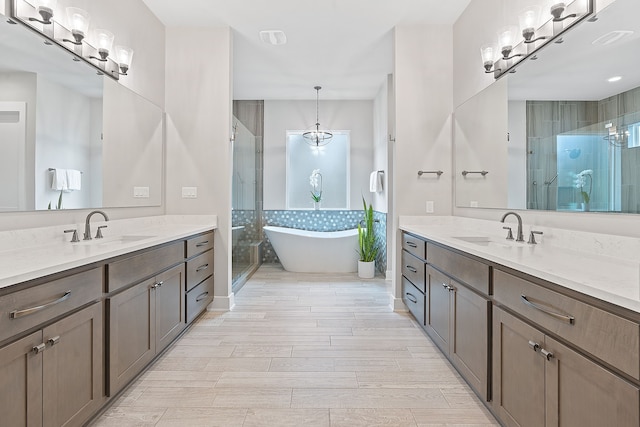 bathroom with vanity and independent shower and bath