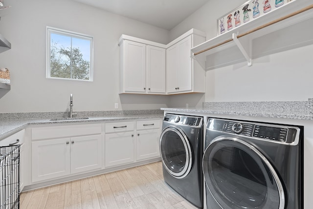 washroom with cabinets, separate washer and dryer, sink, and light wood-type flooring