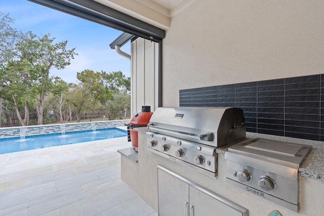 view of patio featuring grilling area, pool water feature, and an outdoor kitchen