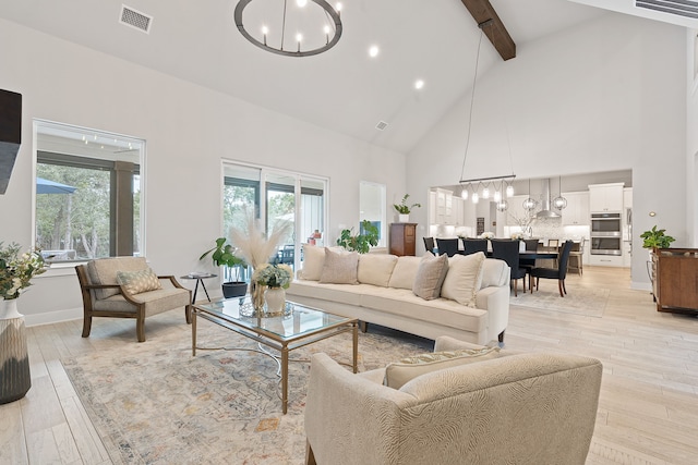 living room featuring beamed ceiling, high vaulted ceiling, light wood-type flooring, and an inviting chandelier