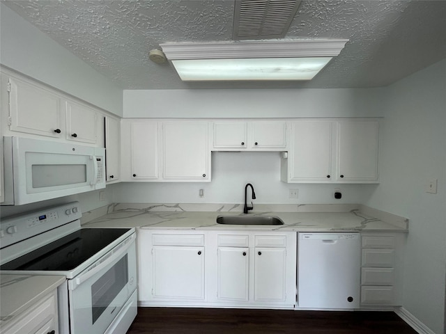 kitchen featuring white cabinetry, white appliances, light stone countertops, and sink