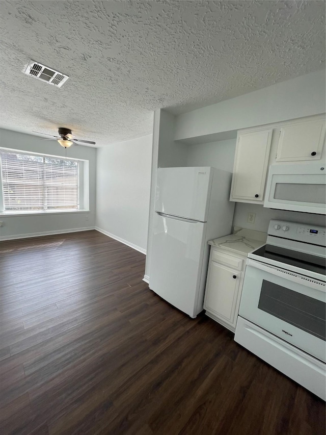 kitchen with white appliances, ceiling fan, a textured ceiling, white cabinets, and dark hardwood / wood-style flooring