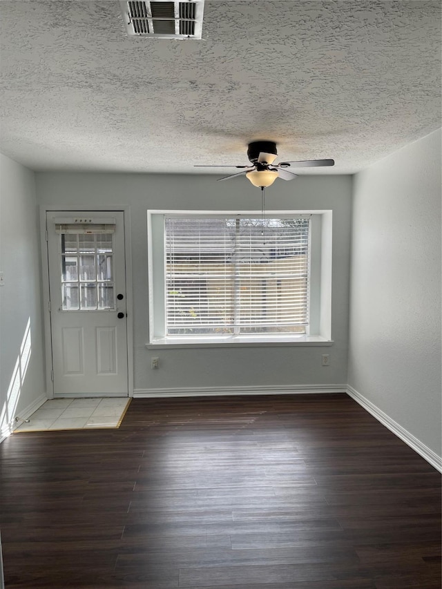 foyer entrance with ceiling fan, dark hardwood / wood-style floors, and a textured ceiling