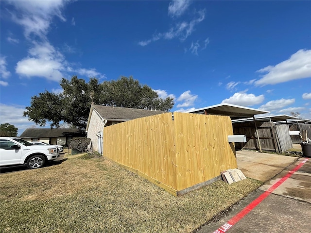 view of side of home featuring a yard and a carport