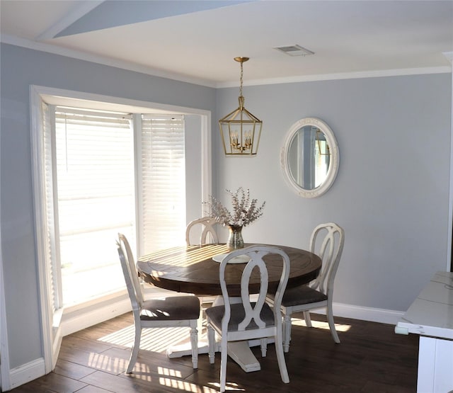 dining area featuring crown molding, dark wood-type flooring, and a chandelier