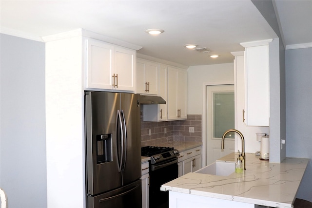 kitchen with sink, appliances with stainless steel finishes, kitchen peninsula, light stone countertops, and white cabinets