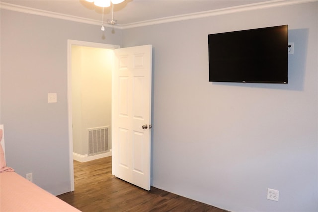 unfurnished bedroom featuring ornamental molding and dark hardwood / wood-style floors