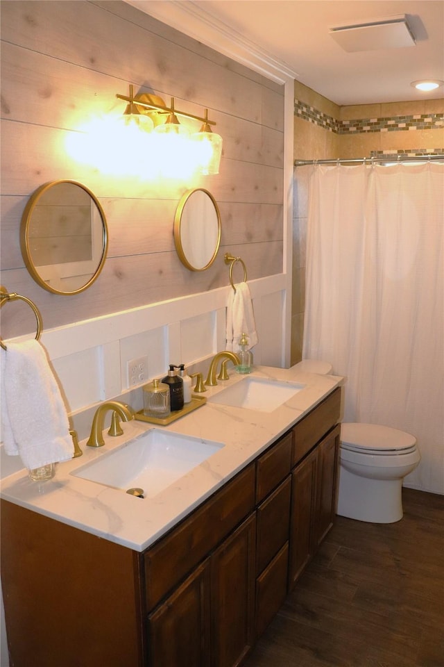 bathroom with wooden walls, hardwood / wood-style flooring, vanity, walk in shower, and toilet