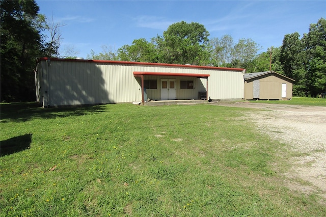 exterior space with an outdoor structure and a front lawn